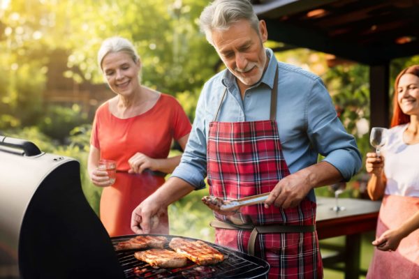 An AI-generated image of a man working the grill as a woman looks at the food cooking and another holds a glass of wine.